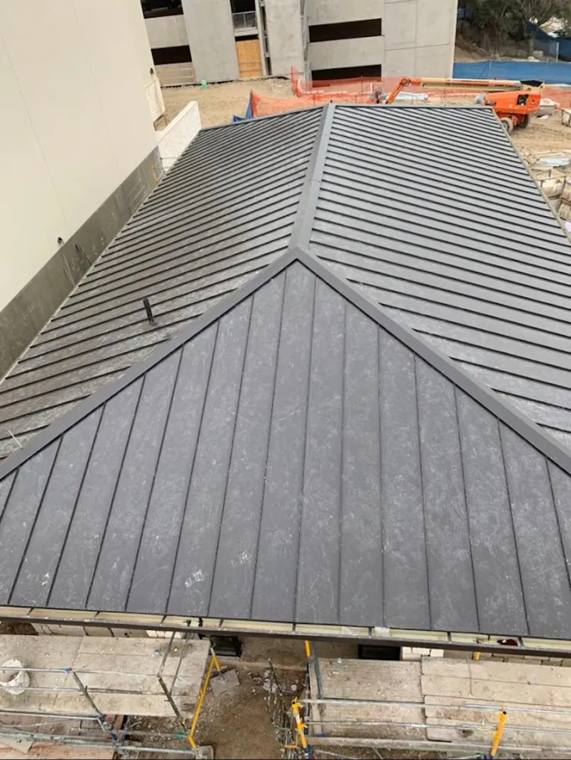 Commercial metal roof construction with crane equipment in Kendall West